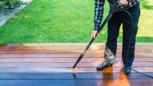 Someone cleaning composite decking with a soft brush and soapy water