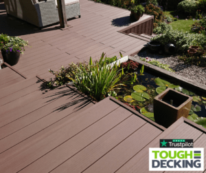 Composite decking in a small garden with built-in seating and planters