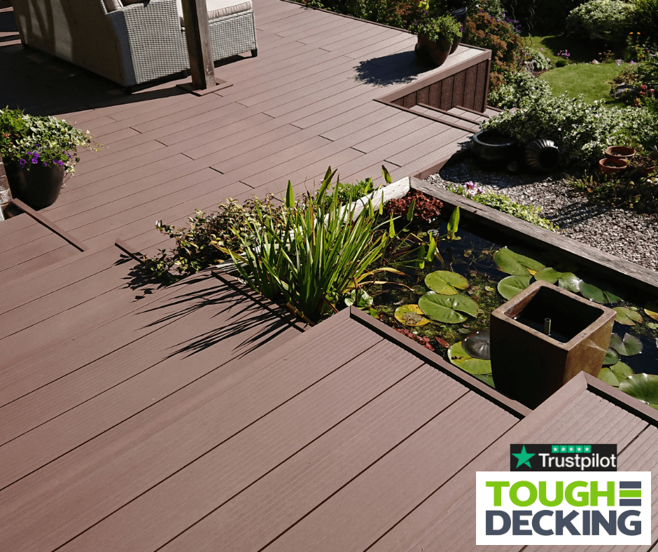 Composite decking in a small garden with built-in seating and planters
